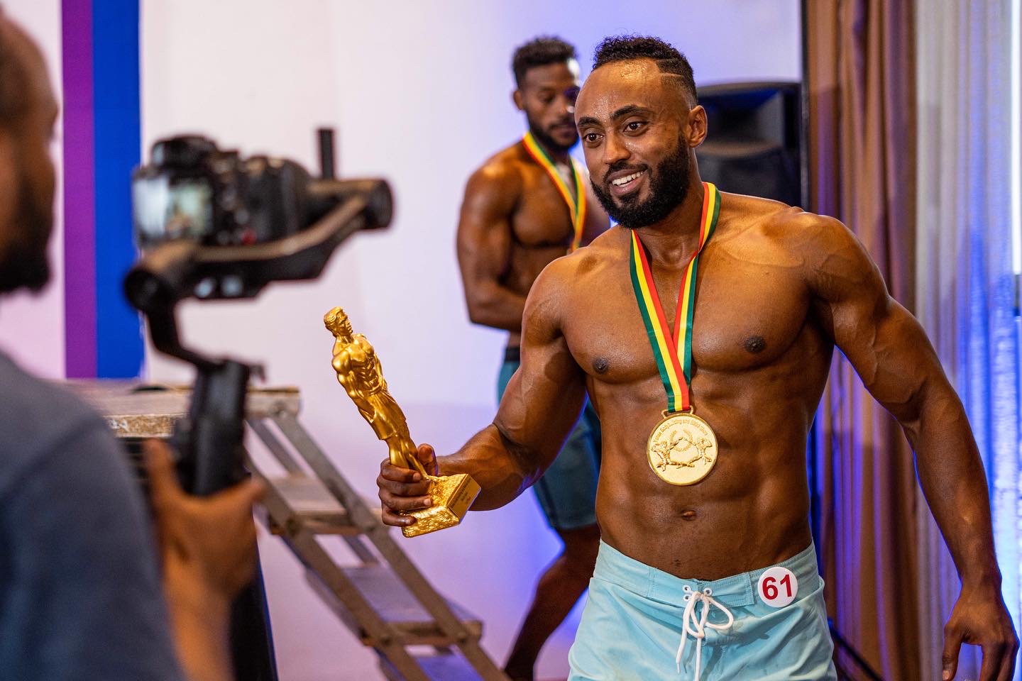 Coach William on Stage with Champion Trophy and Gold Medal